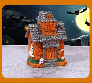Detail of resin Halloween haunted house miniature with ghost and pumpkin decorations