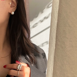 Elegant 925 silver pearl earrings and textured metal rings set on female model