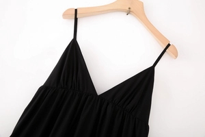 Détail d'une robe midi noire en coton avec col en V et fines bretelles sur cintre