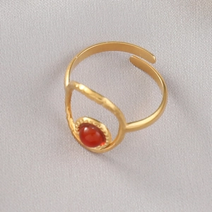 Detail of adjustable gold ring with vintage wave border and red gemstone setting