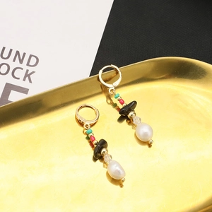Vintage Baroque pearl earrings with black onyx and 18k gold plating in a gold tray