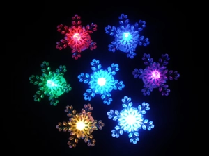 Detail of colorful snowflake LED lights in seven vibrant colors on a black background