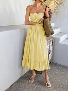 Detail view of yellow A-line dress featuring ruffle hem and delicate waist lace-up straps