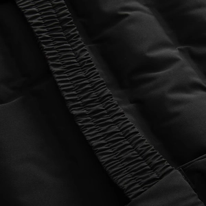 Close-up of black quilted polyester jacket showing elastic hem and matte fabric texture