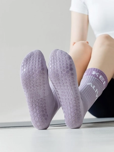 Close-up of purple yoga socks featuring non-slip grip soles and stylish calf lettering