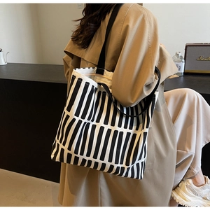 Detailed side view of a large canvas tote bag with black and white geometric patterns