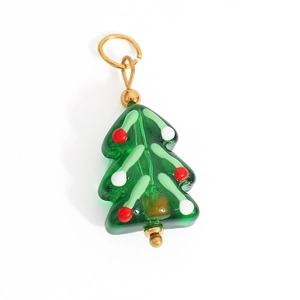 Detailed macro view of a green translucent Christmas tree pendant with gold metal bail