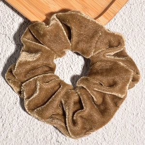 Detail shot of brown velvet scrunchie showing fine fabric texture and soft metallic sheen