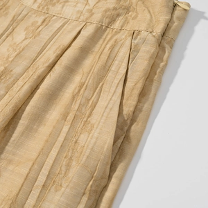 Detailed macro shot of champagne gold jacquard fabric with subtle stripes and side pockets