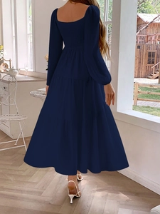 Detail view of deep blue woven long-sleeve dress with smocked back and tiered skirt layer