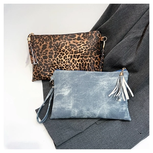 Flat lay of leopard print and denim blue envelope clutches with stylish tassel zippers