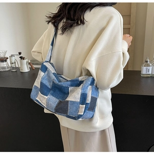 Sac bandoulière en patchwork de denim porté par un mannequin dans un décor intérieur