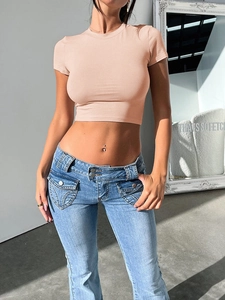 Detail of pink slim-fit crop top and low-rise blue denim flare jeans on a model