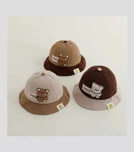 Detailed view of corduroy baby sun hats featuring cute bear patches and color-block design