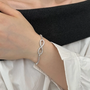 Elegant silver Mobius bracelet with sparkling zircons on model's wrist with high-end look
