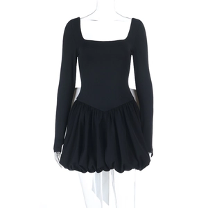 Détail du dos d'une robe noire courte avec un grand nœud blanc et une jupe boule