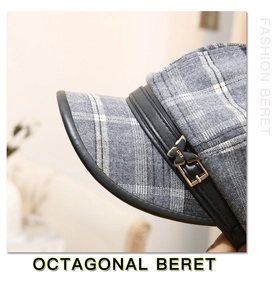 Detail of the golden butterfly metal buckle with LOVE engraving on a gray plaid beret
