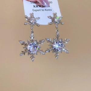 Detailaufnahme von Schneeflocken-Ohrringen aus Silber mit Zirkonia-Steinen und Perlen
