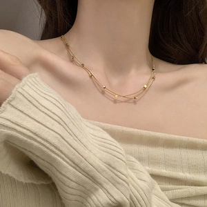 Double-layer titanium steel necklace with square pendants worn on a beige knit sweater