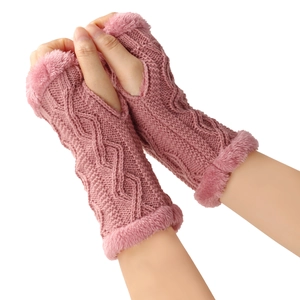 Détail de gants tricotés sans doigts rose poudré avec bordure en fausse fourrure douce hiver