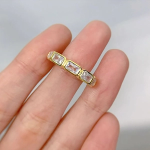 Detailed view of emerald cut cubic zirconia eternity band in gold plating on finger