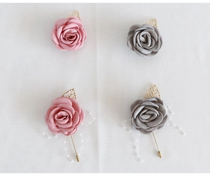 Détail de boutonnières roses en satin faites main avec feuilles en métal et perles