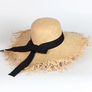 French raffia sun hat with wide brim, black ribbon bow, and frayed edges for beach vacations