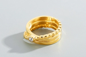 Macro detail of gold stainless steel multi-layered ring with sparkling zircon inlay