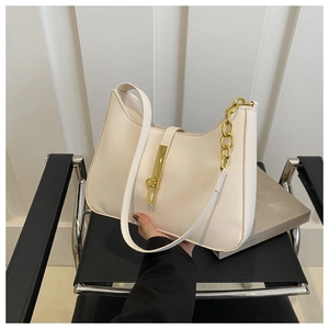 Close-up of cream leather shoulder bag with gold metallic buckle and chain strap detail