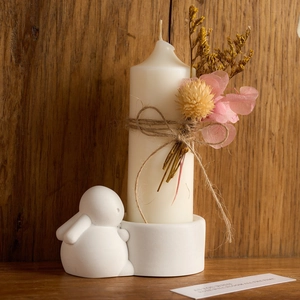 Easter bunny candle holder with floral candle and wooden background home decor