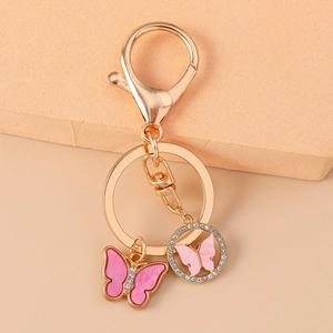 Detailed macro view of pink enamel butterfly pendant with sparkling rhinestones on gold keychain