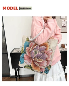 Close-up of embroidered floral canvas tote bag with cotton rope handles shown on model
