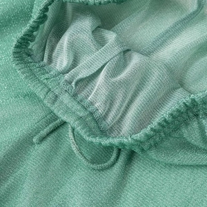 Détail du tissu en maille verte scintillante avec cordon de serrage et texture brillante