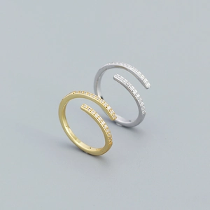 Macro detail of silver and gold geometric open rings with sparkling zircon inlay
