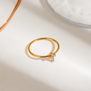 Close-up of gold thin stackable ring with four white zircon stones in a cross pattern