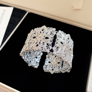 Détail d'un bracelet jonc argenté vintage avec motif floral en filigrane ajouré