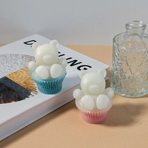 Détail de deux bougies ours 3D sur des bases de cupcakes roses et bleues décoratives