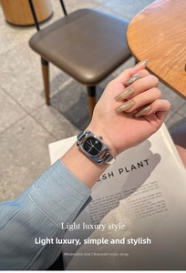 Detailed close-up of a silver square watch with a bangle strap on a woman's wrist