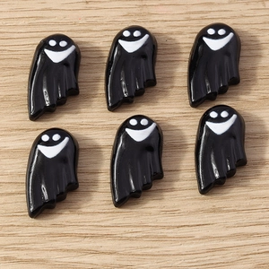 Close-up of black resin ghost charms with smiling faces for Halloween DIY projects