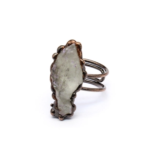 Macro detail of a handmade vintage ring featuring a light green agate geode in bronze setting