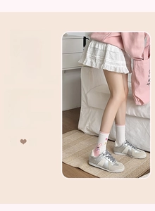 Détail d'une chaussette en coton blanc avec motif chat rose et bordure élastique