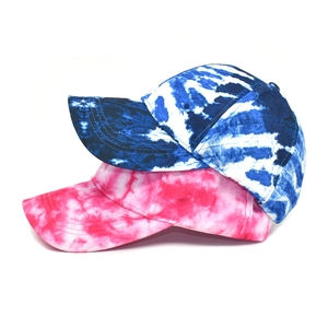 Detail of tie-dye baseball caps in blue, pink, and white featuring six-panel construction