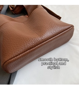 Gros plan détaillé du fond large lisse et du cuir grainé de ce sac cabas marron élégant