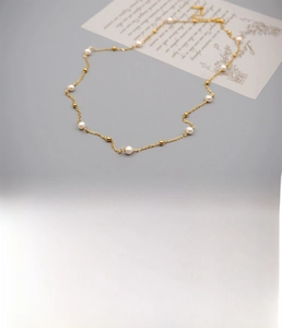 Détail du collier fait main en acier titane doré avec perles d'eau douce et spécifications