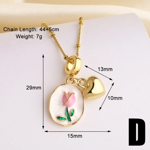 Macro view of gold chain with white tulip enamel pendant and heart charm detailing