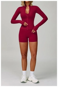 Dettaglio del set yoga rosa scuro con giacca slim dotata di asole per i pollici e shorts
