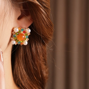Gros plan d'une boucle d'oreille carrée vintage avec cristaux colorés et perle