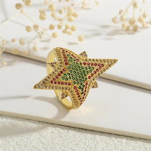 Detailed macro view of 18K gold star ring set with white, green and red zircons