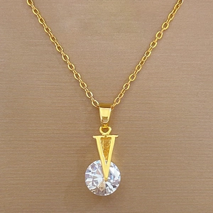Detail of V-shaped gold titanium necklace featuring a large brilliant-cut zircon pendant