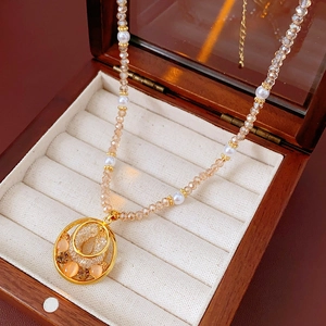 Detail of opal pendant pearl necklace with gold inlay on a velvet jewelry box
